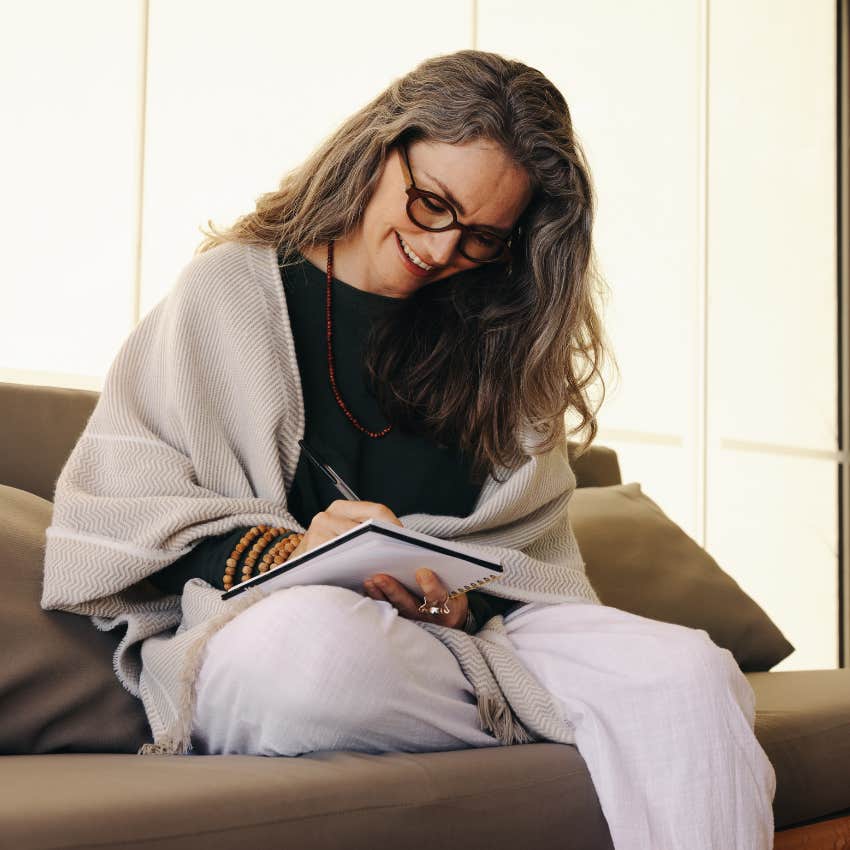 happy older woman smiling while journaling
