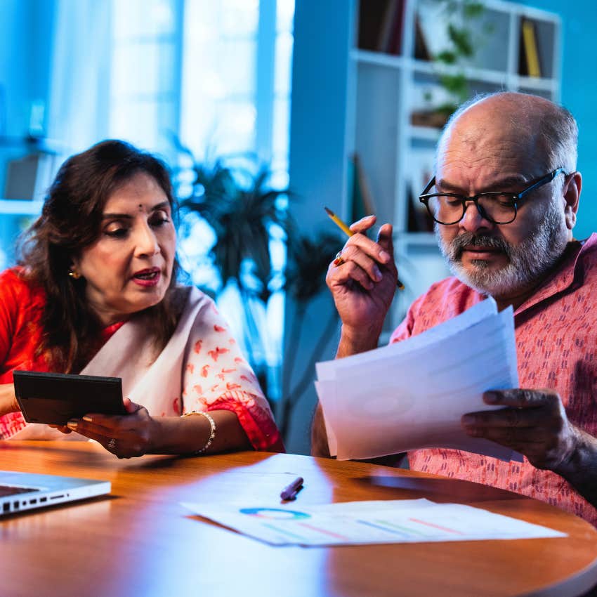 Middle-aged couple balancing their checkbook at home.