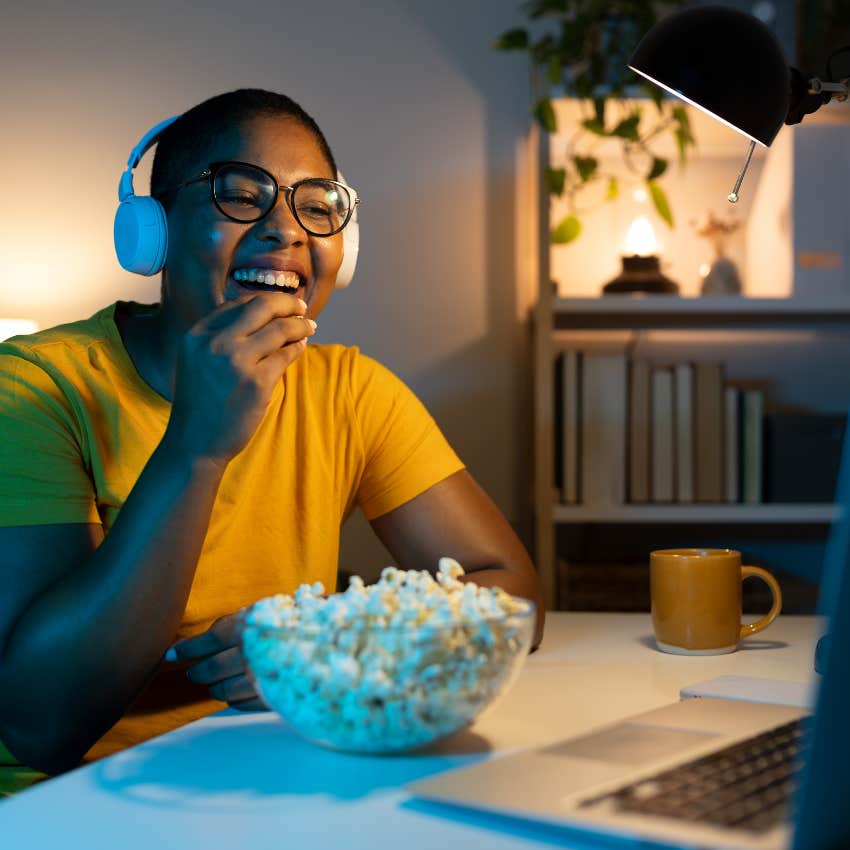Woman who's an imaginative person watching a movie at home.