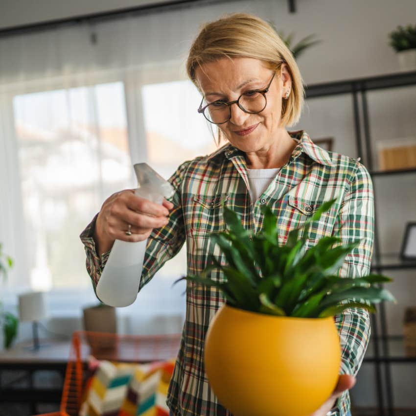 Woman gardening and tending to plants at home.