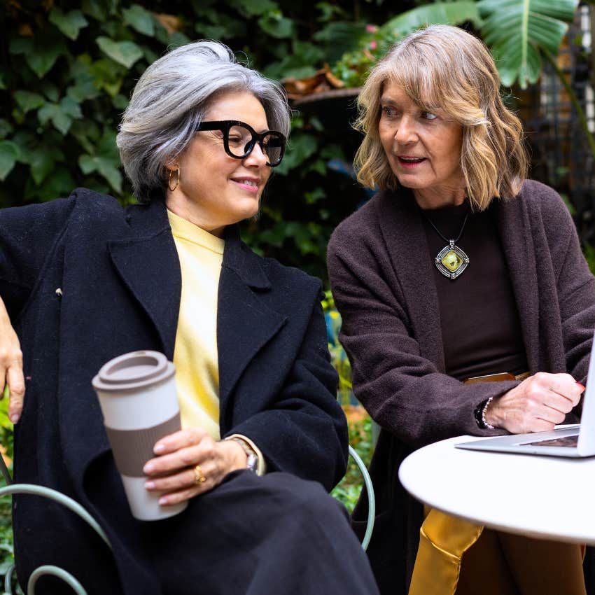 Woman who doesn't immediately react sitting with her friend outside.