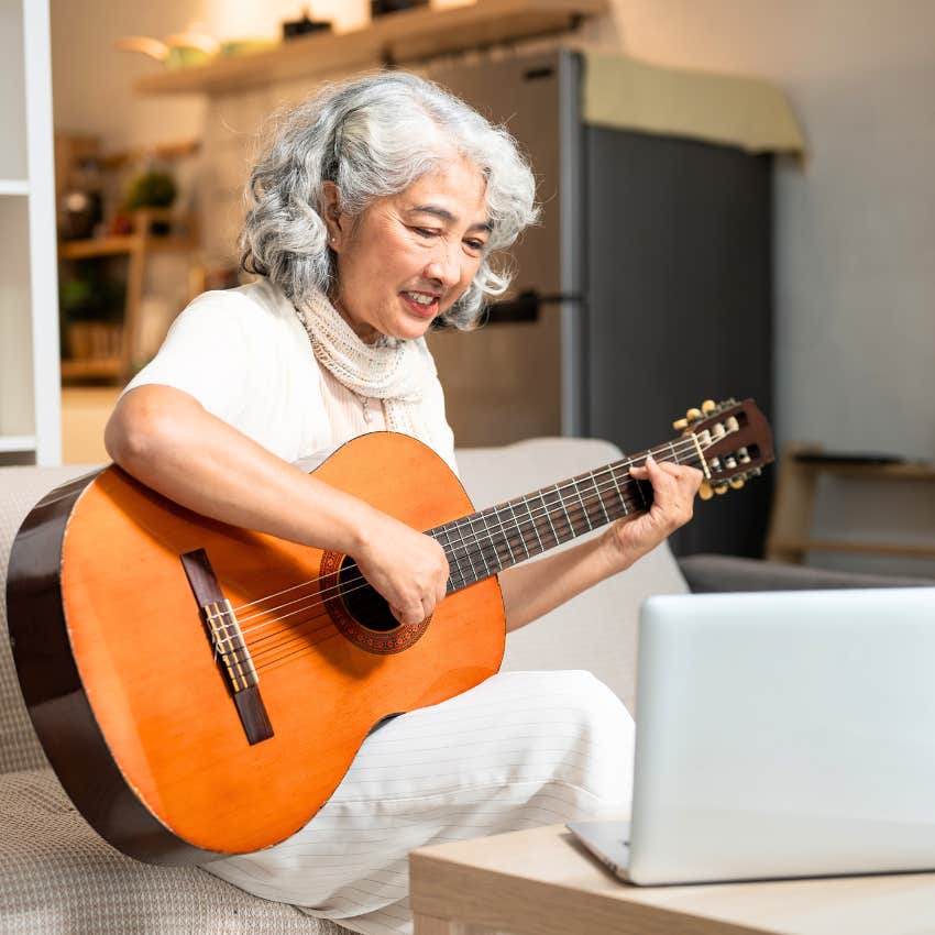older woman with a busy mind playing the guitar for comfort