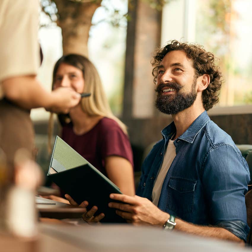 Man who's extroverted and loves getting out of the house sitting in a restaurant