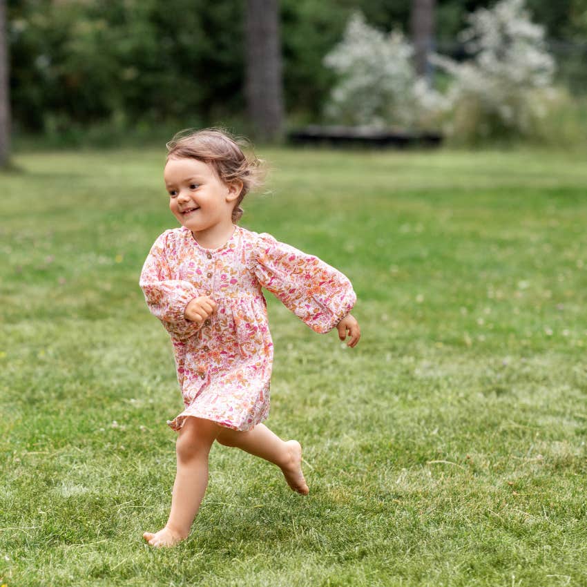 little girl living in the moment while running through her yard