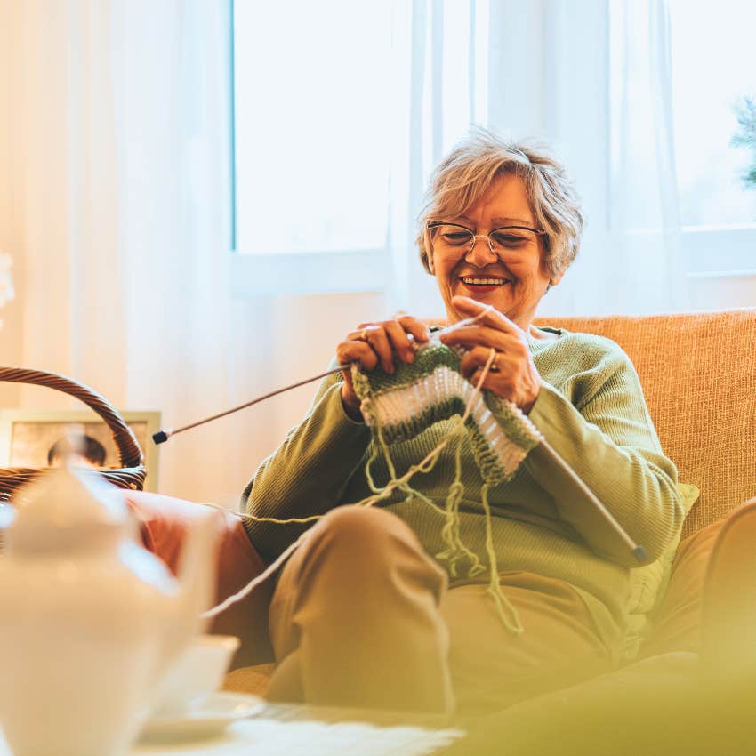 happy older woman knitting in her living room