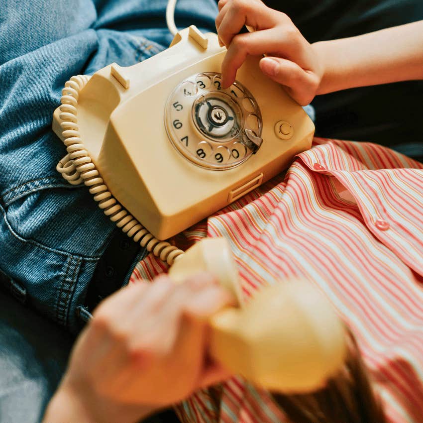 person using rotary dial phone