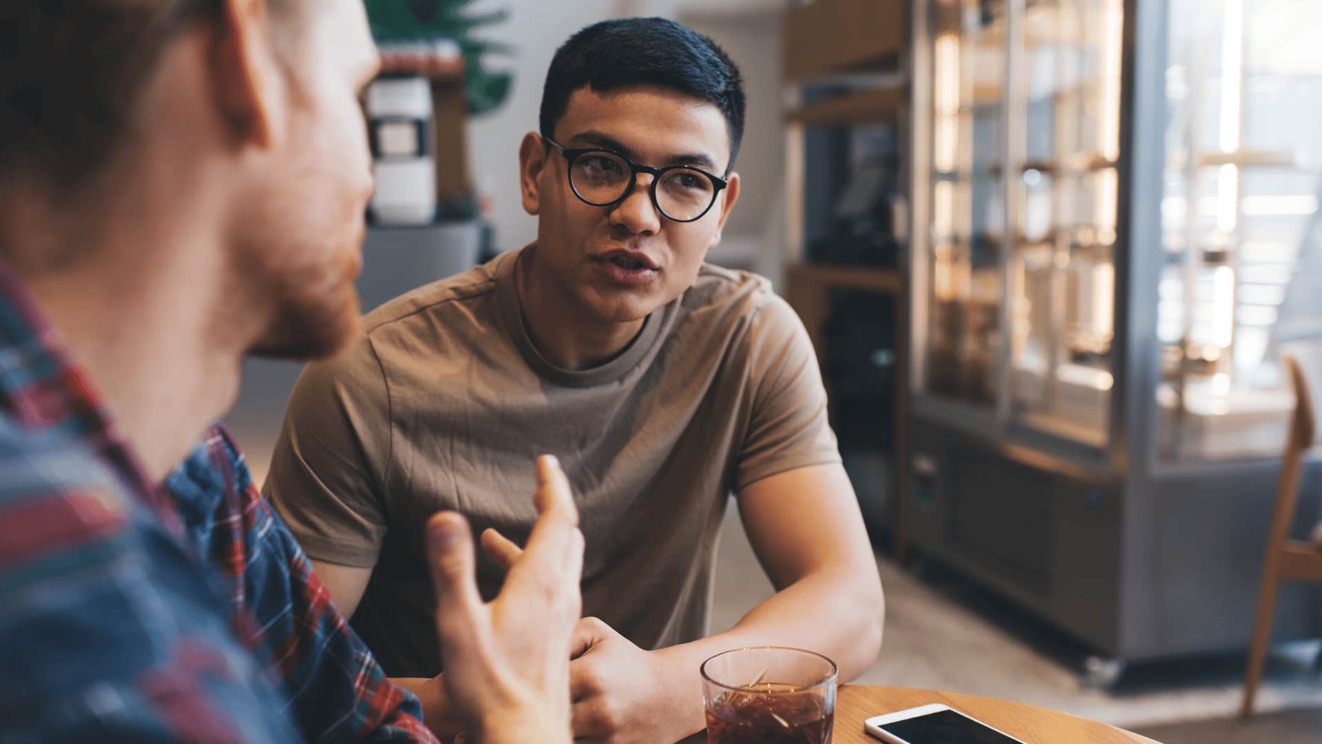 man talking to friend explaining he's really busy