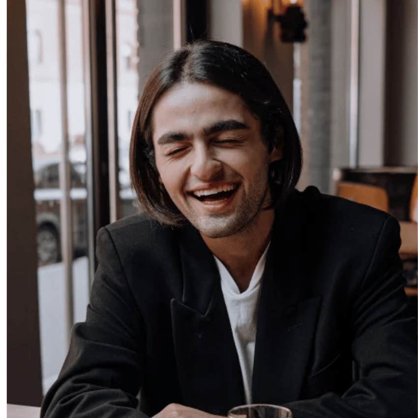 Man pretending to be happy laughs while telling friends i'm just joking