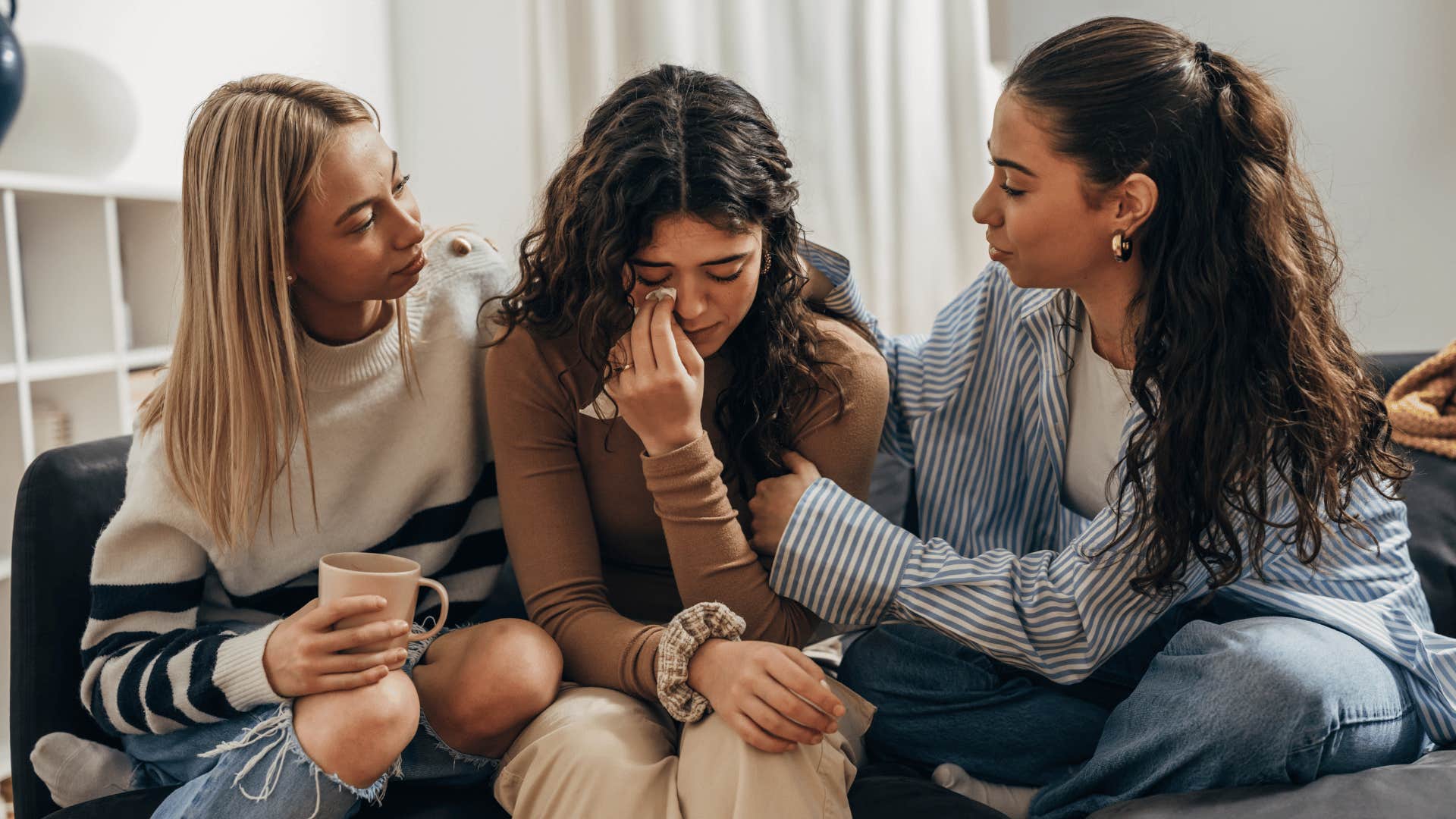 friends comforting woman crying about her sad relatioship