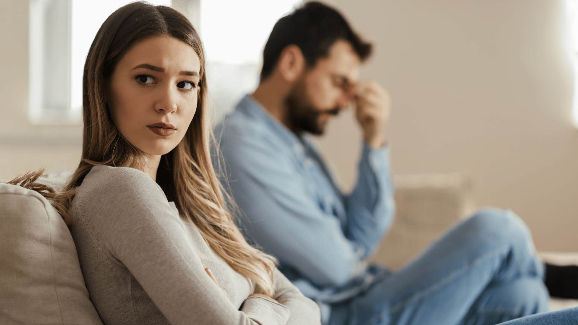 sad woman sitting next to husband saying we live separate lives