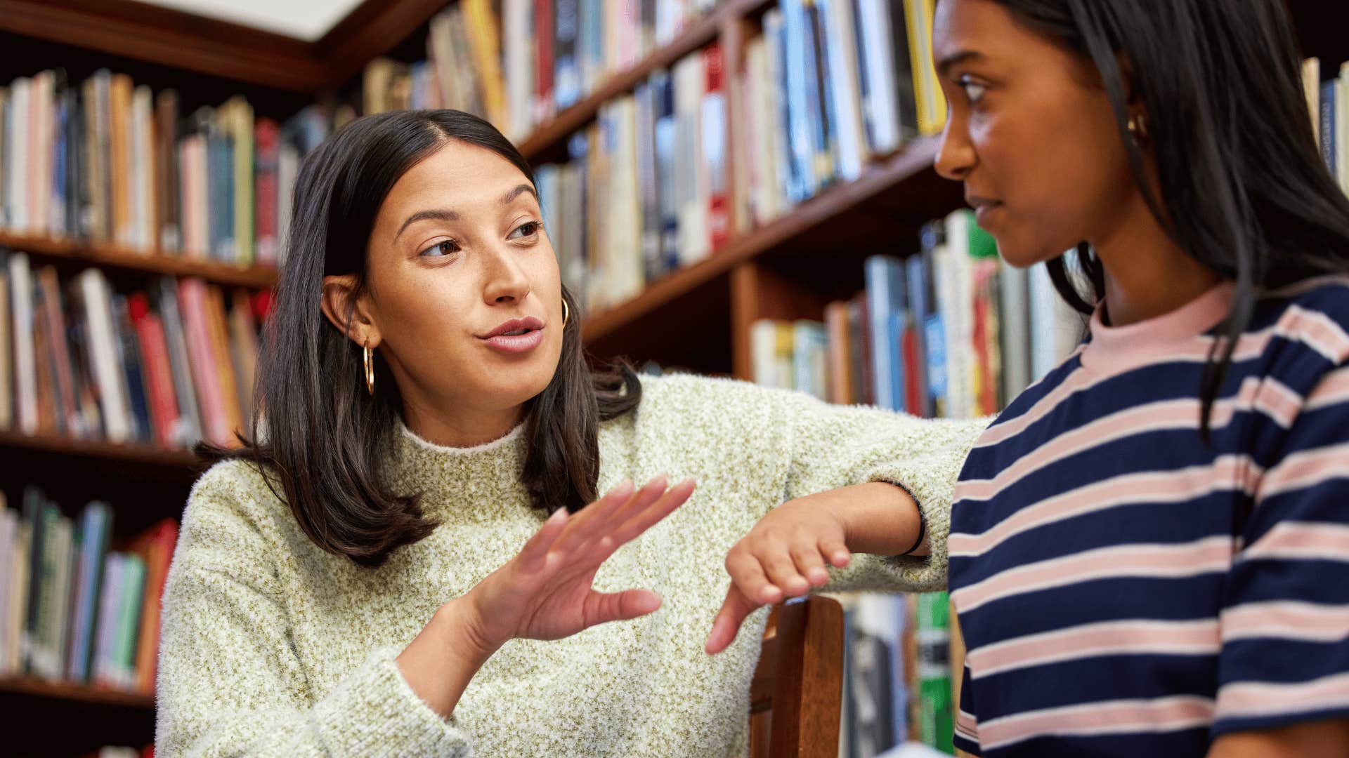 authentic kind woman speaking to friend in the library about her feelings