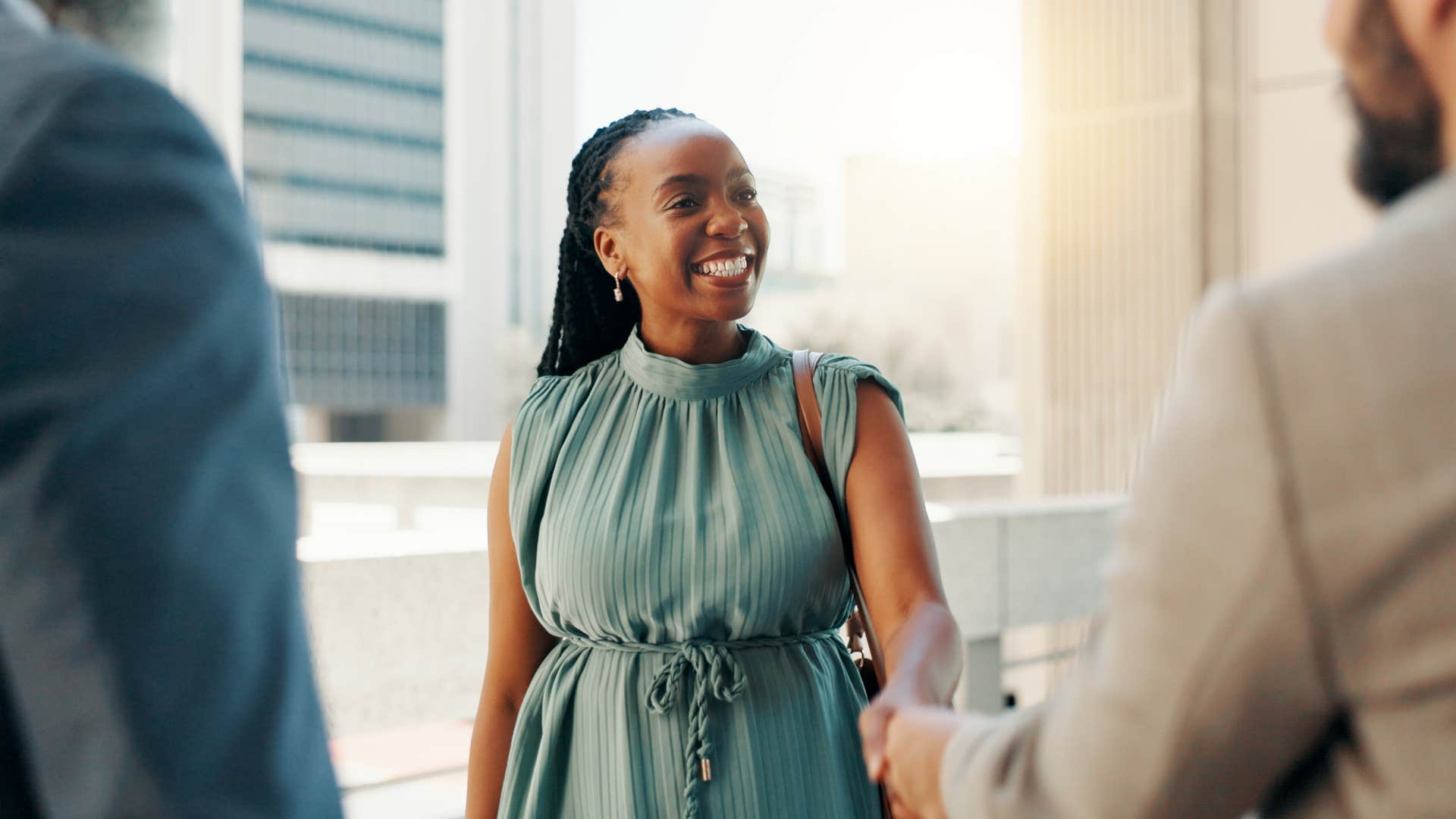 smiling woman shaking hands with colleagues