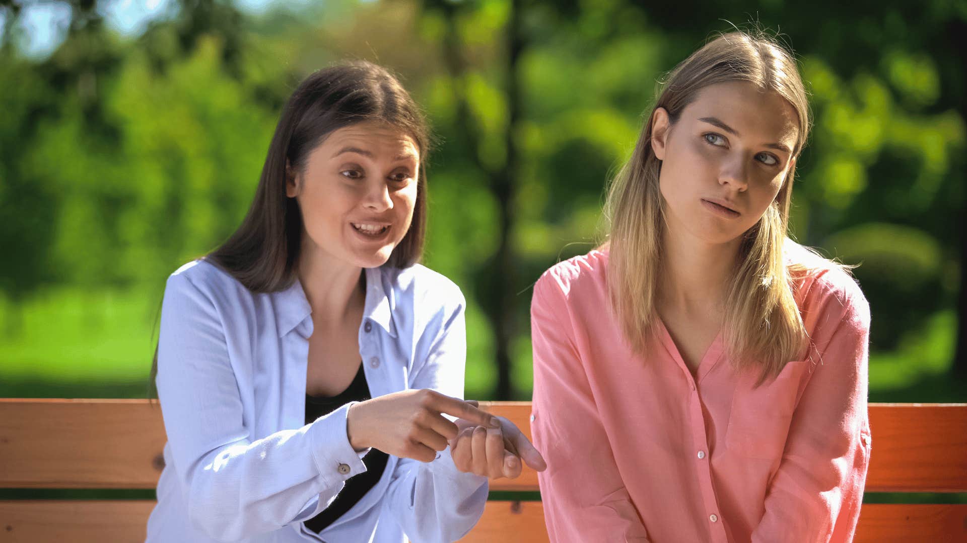 rude unkind woman sitting next to friend telling her i don't owe anyone anything