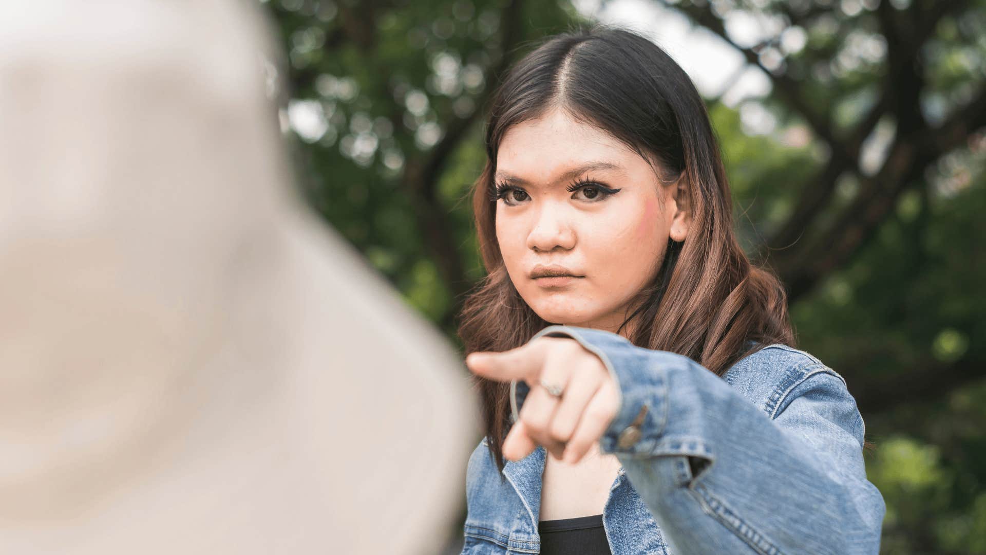 unkind woman pointing at friend saying you need to get over it