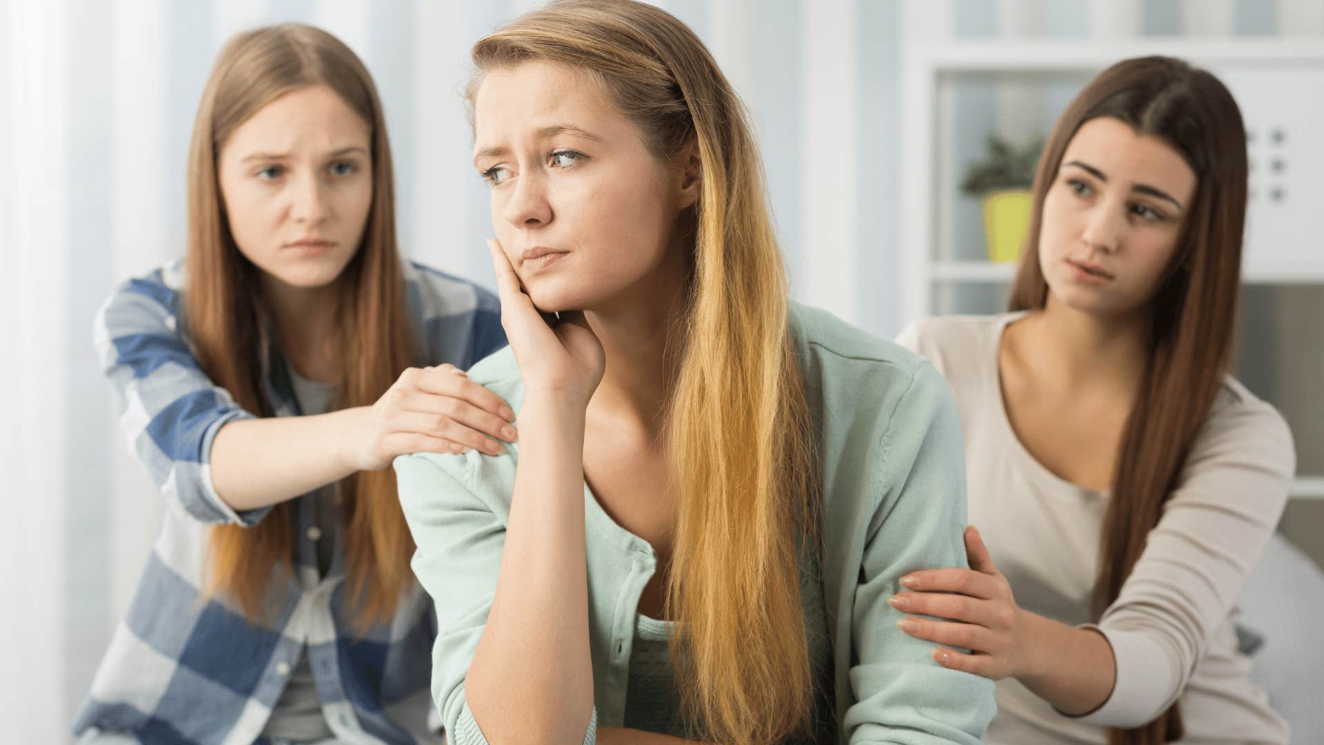 women comforting friend who is saying she's fine