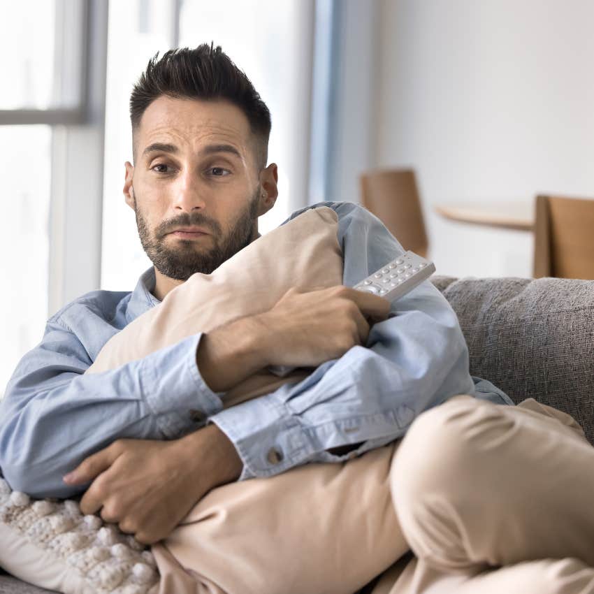 adult man feeling emotional on his couch at home