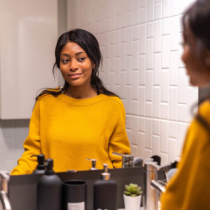 woman looking at herself in mirror 