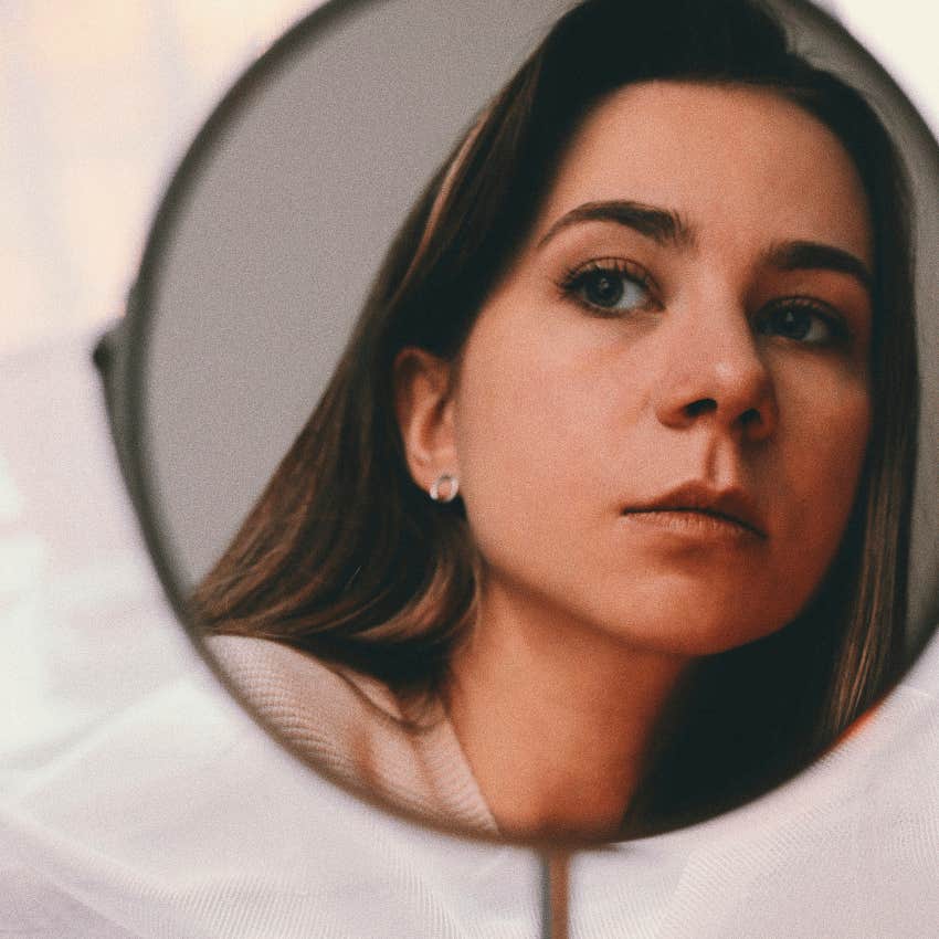 serious woman looking at her own reflection