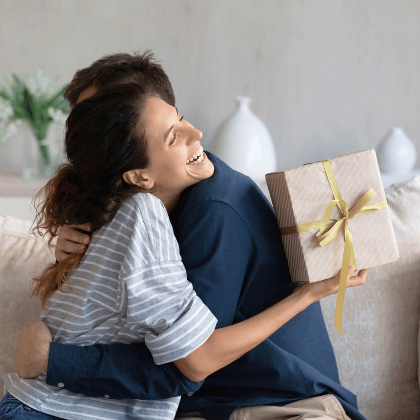 smiling young woman accepting gift from man