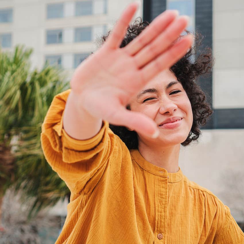secretly ashamed woman trying to block her photo from being taken