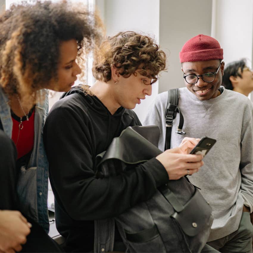 Person interrupting a casual conversation to look up a fact on their smartphone instead of listening