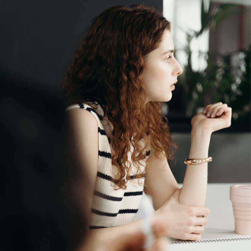 Ethical employee looking concerned during a workplace meeting while noticing something that seems wrong