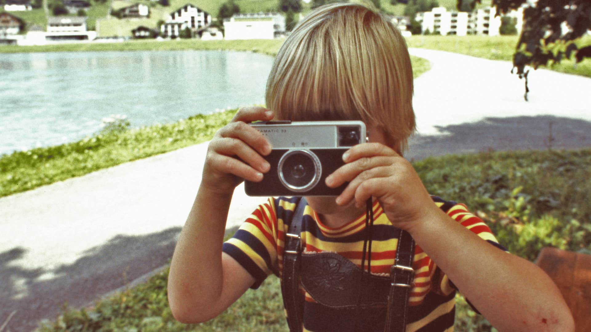 young boy in the 1970s using a film camera