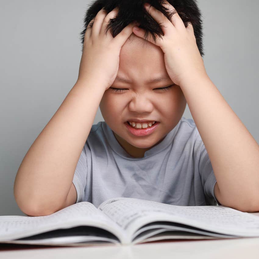 stressed child doing their homework themself