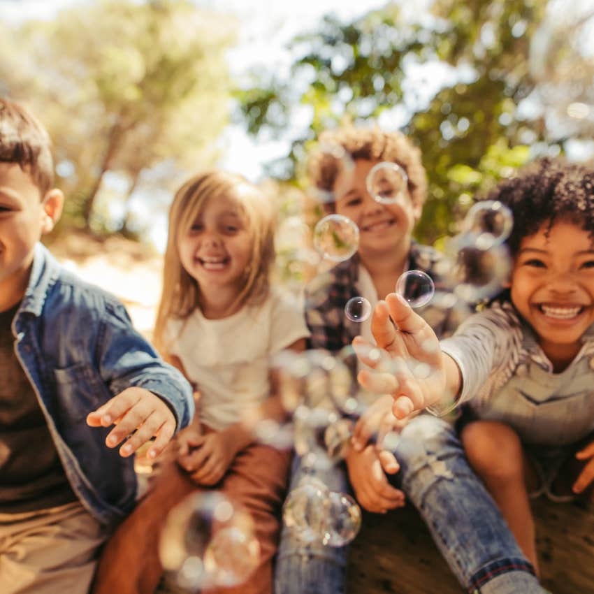 group of kids blowing bubbles outside