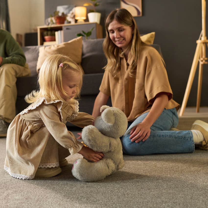 woman with an exceptionally calm mind with her daughter and a stuffed animal at home