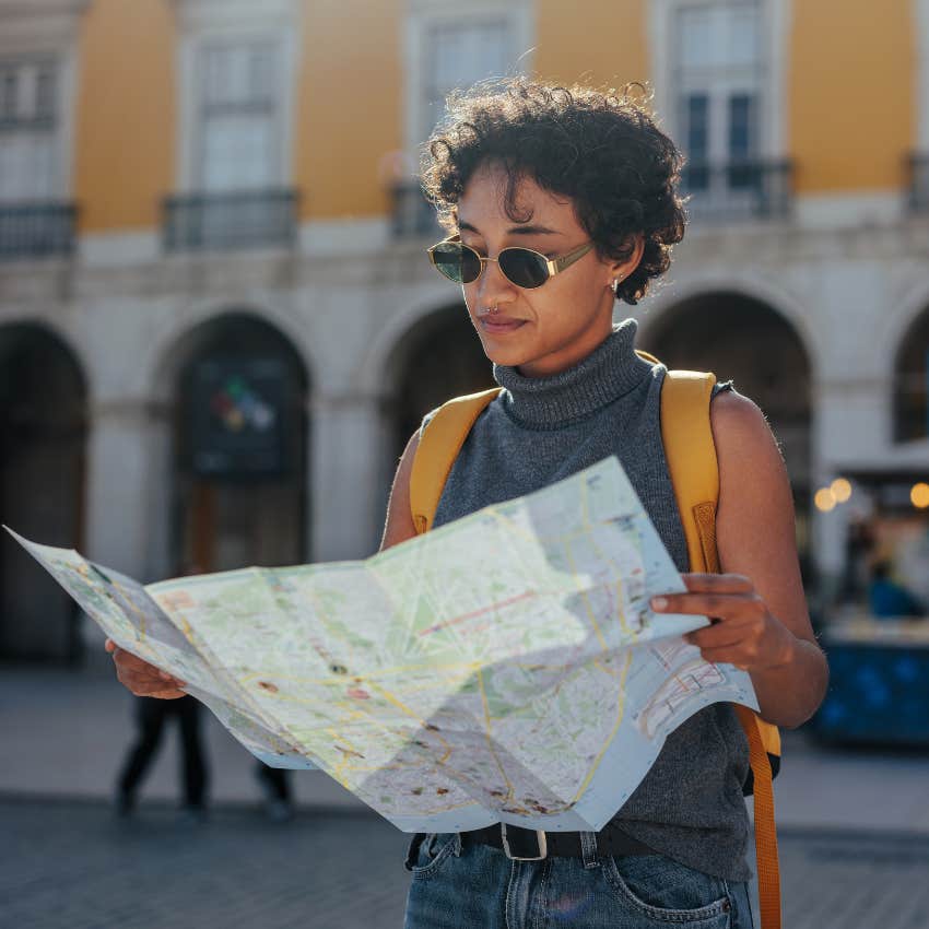 woman who doesn't need a man to rescue her traveling solo looking at map