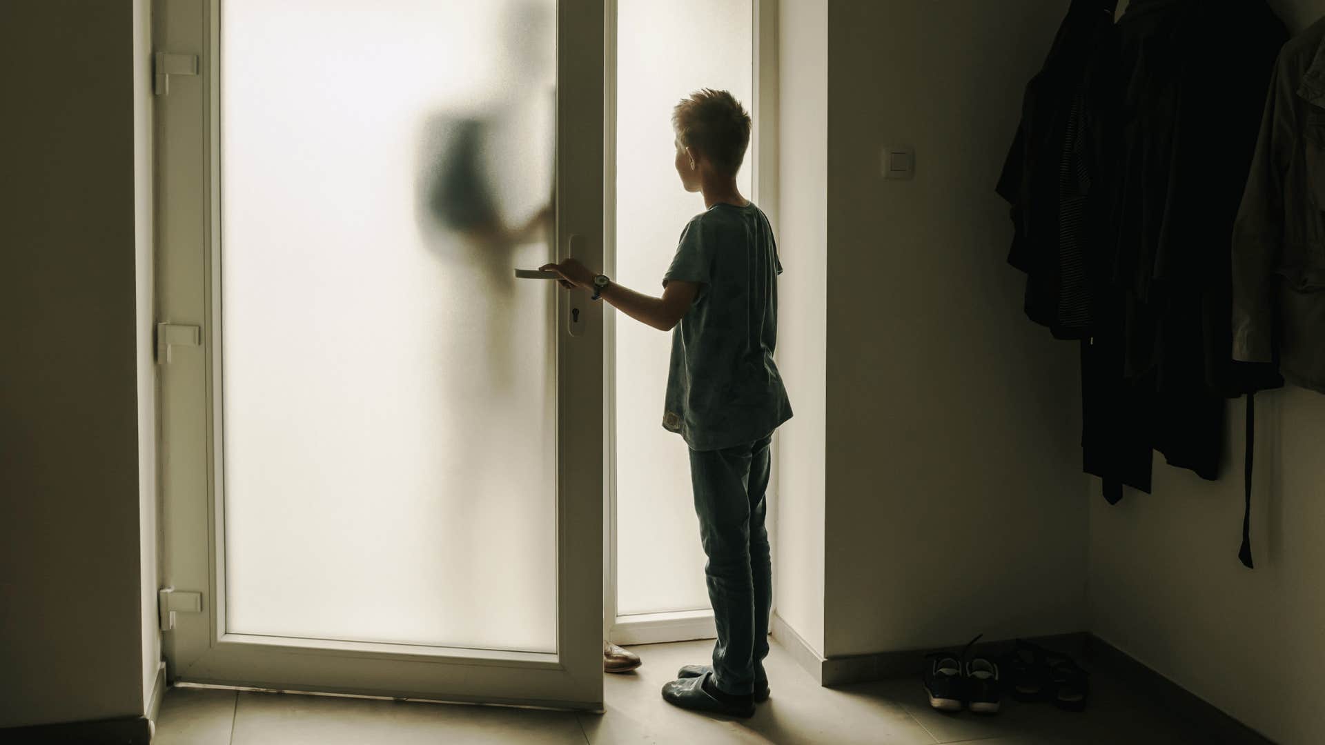 young kid answering the front door by himself