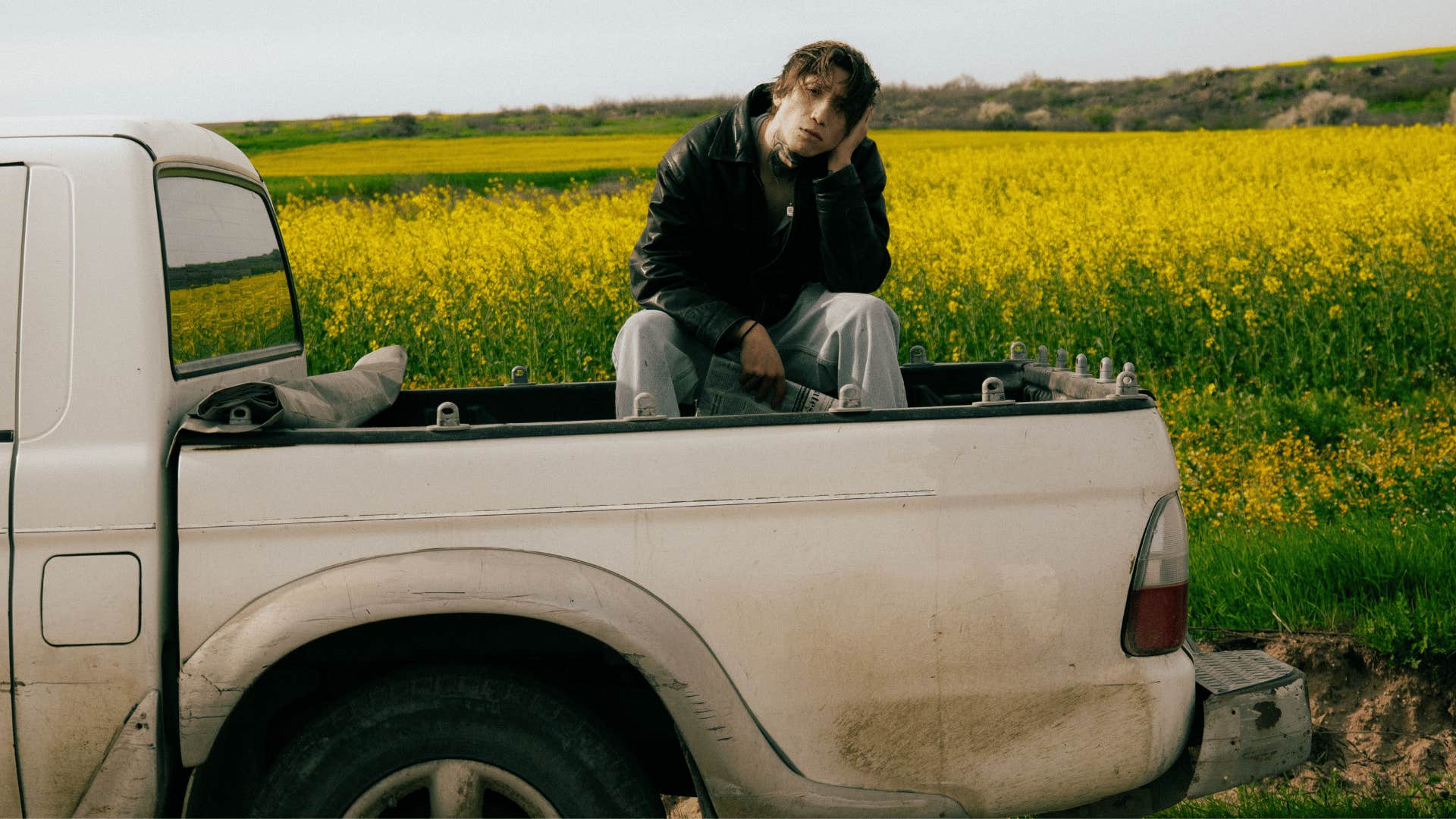 teenage boy riding in the back of a pick-up truck
