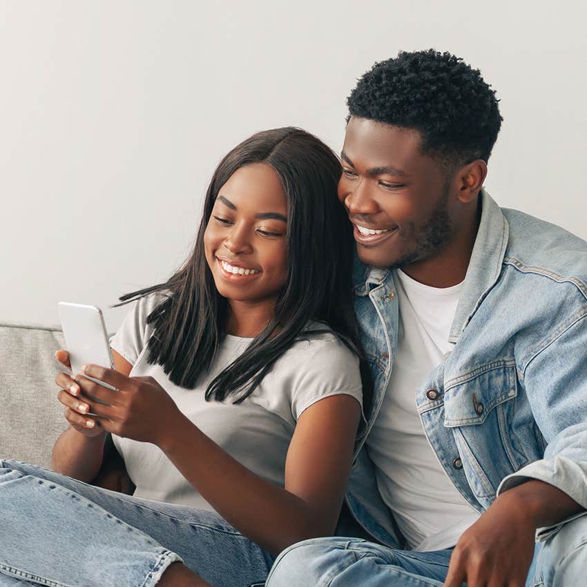 cute millennial couple looking at phone together