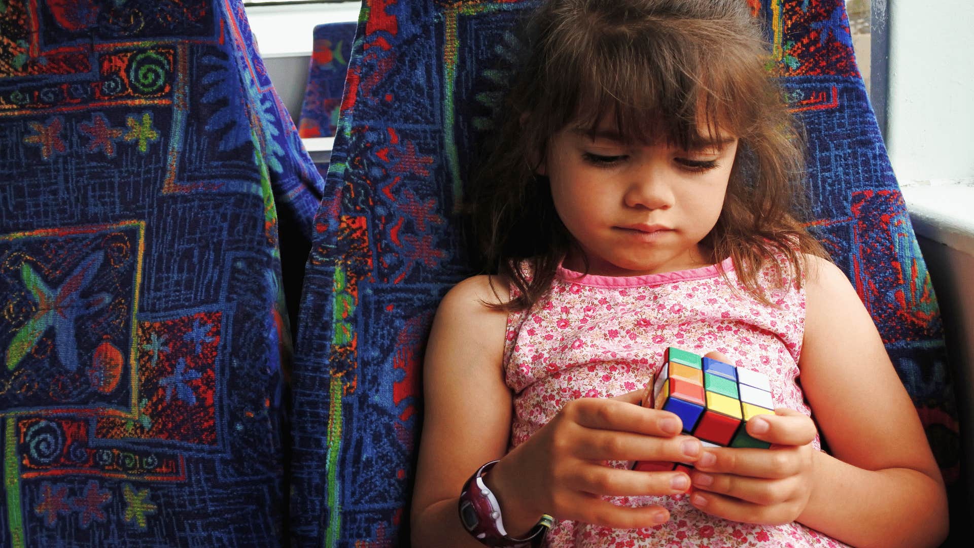 young girl playing with rubik's cube appreciating what she has