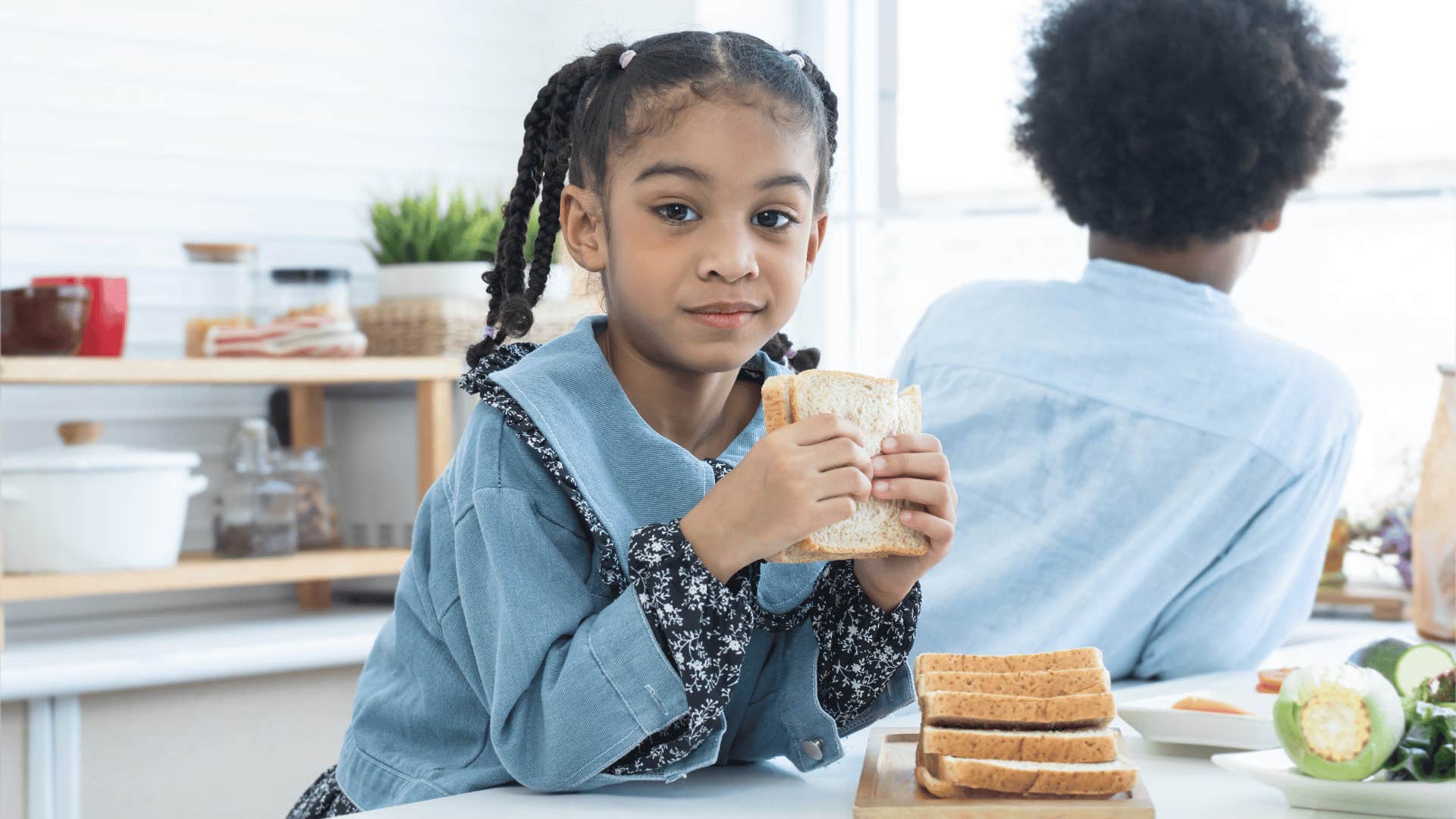 young girl learning accountability and independence making her own food