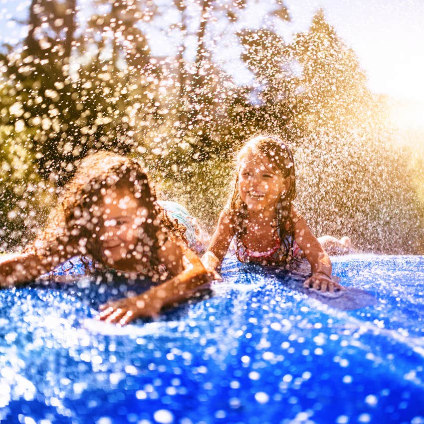 Little girls playing on a slip and slide in their front yard
