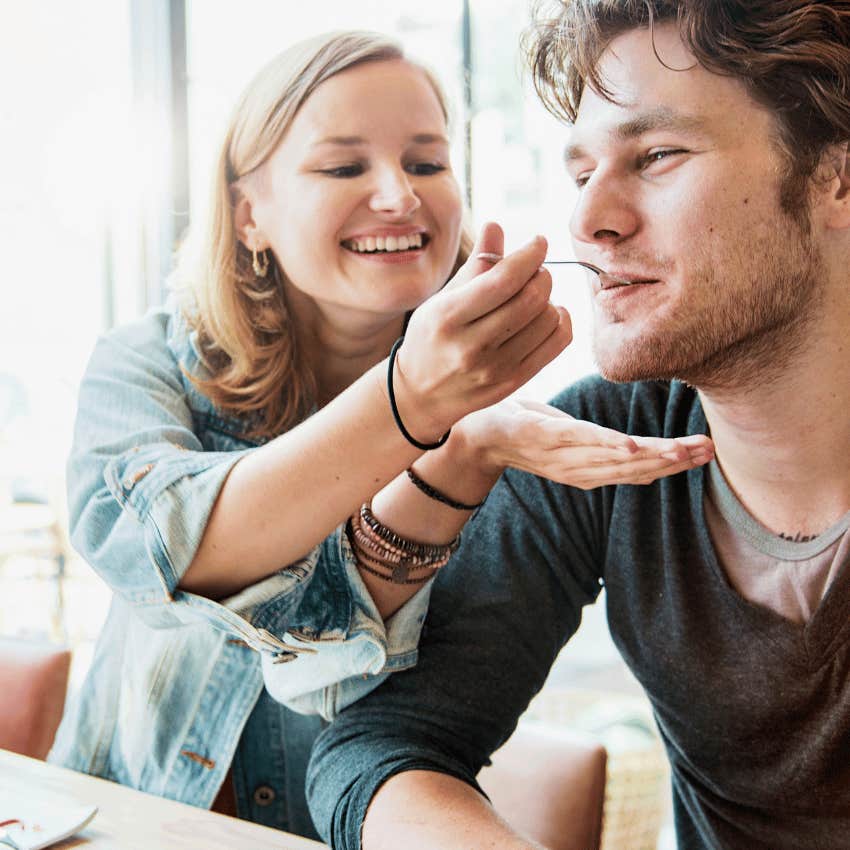 woman hand-feeding man who is looking for someone to foot the bill 