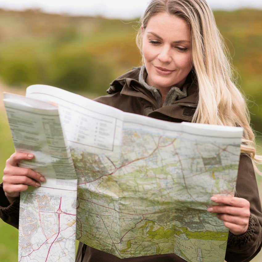 woman reading a large paper map