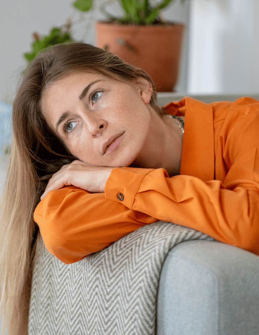 woman in orange shirt miserable as she is adulting