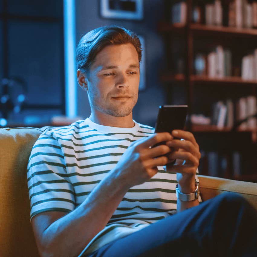 young man focused on his phone online dating profile