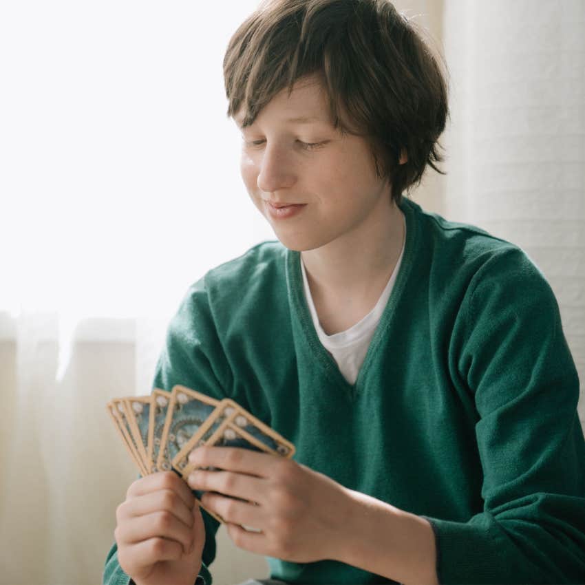 Child examining and organizing a collection of cards and researching information about the items