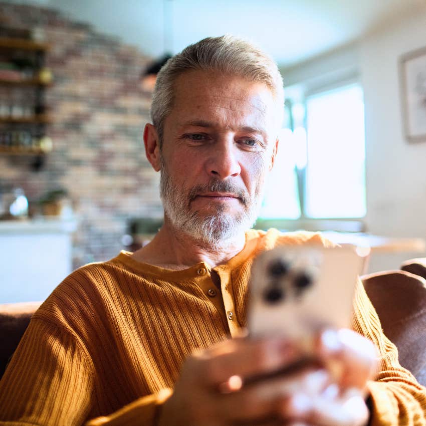 gen X man texting K to his adult kids on his phone