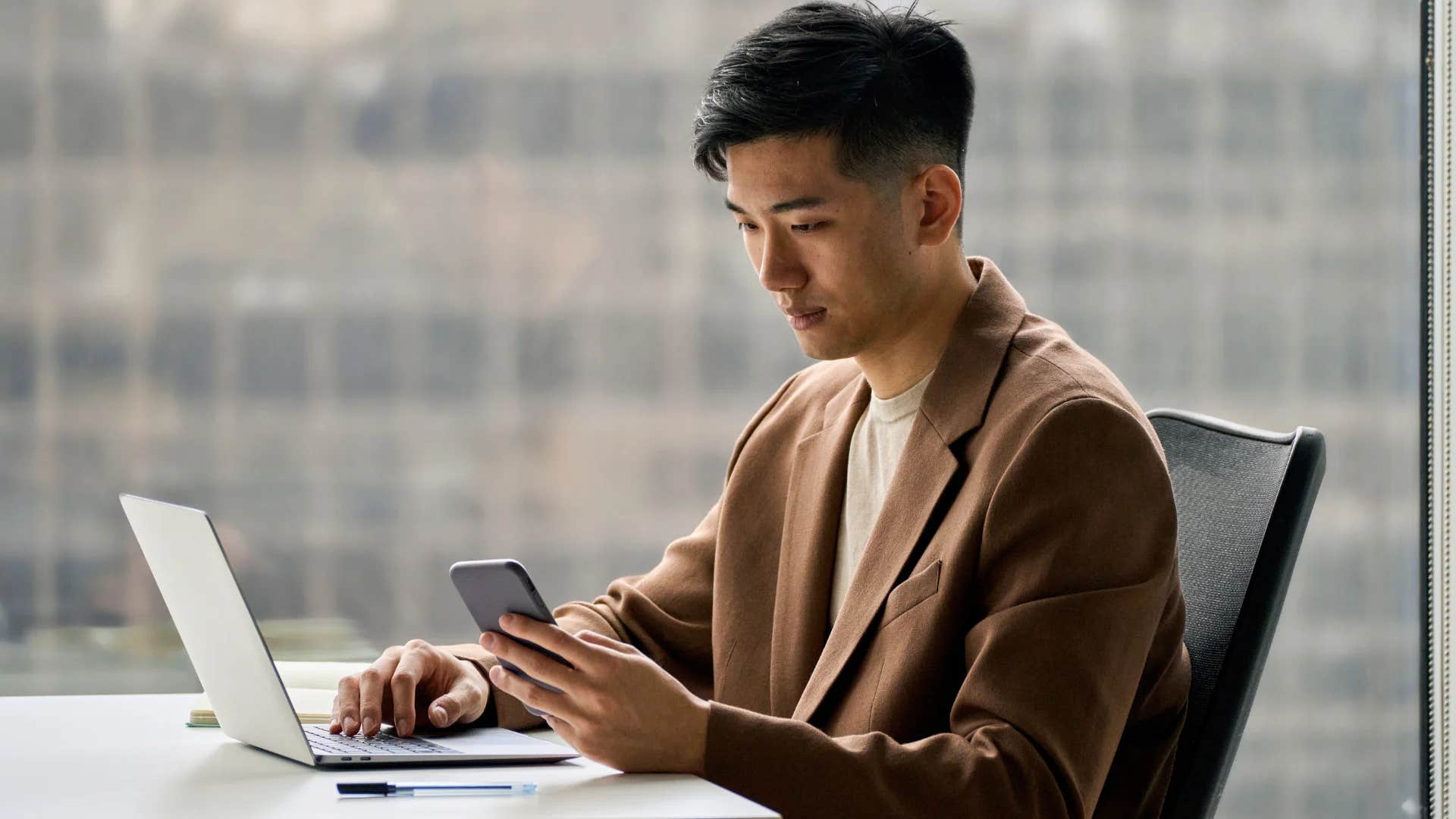 gen Z man on his phone avoiding socializing at work