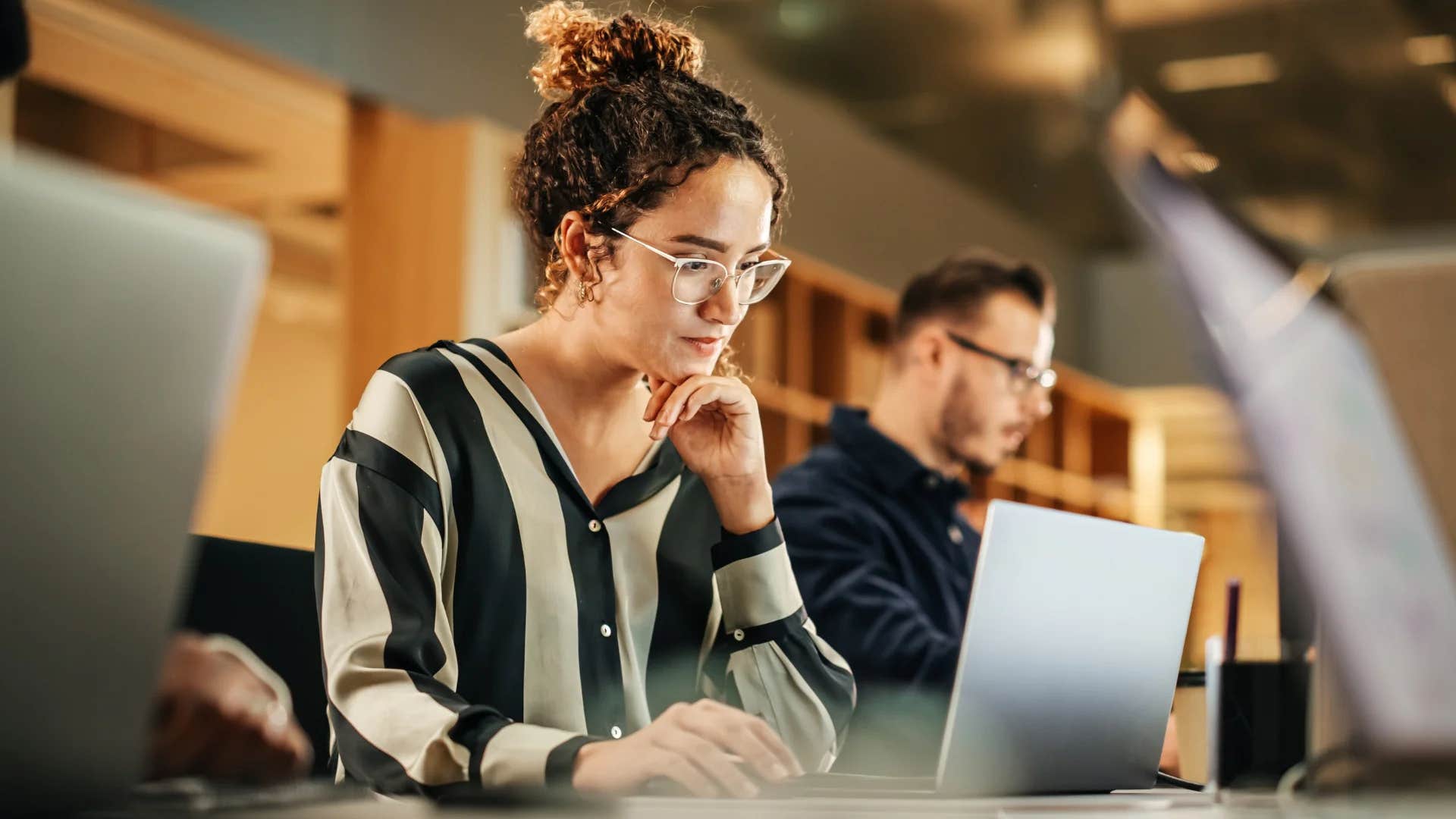 gen Z woman working hard in the office looking at computer