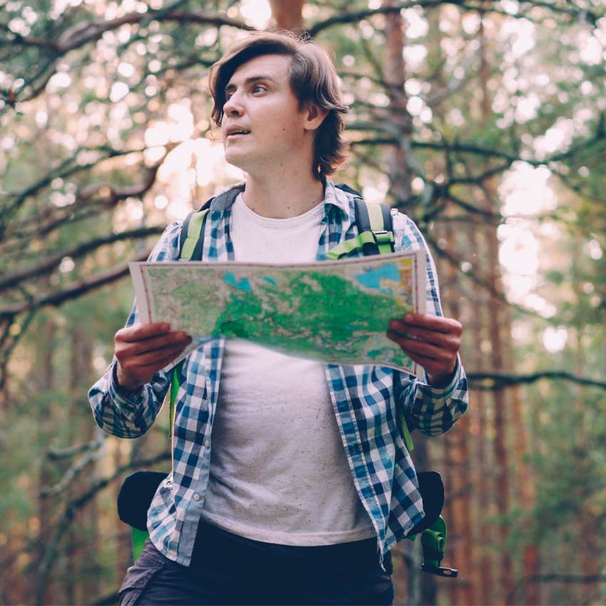 young man trying to use a paper map for directions