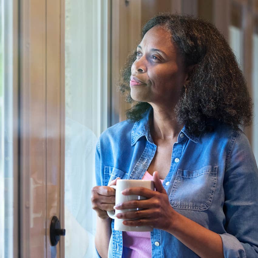 reflective woman looking out the window