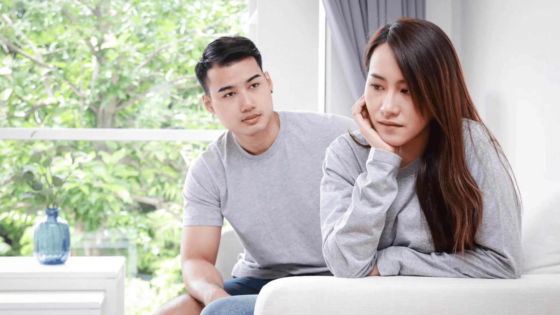sad woman turned away from her partner thinking about their relationship