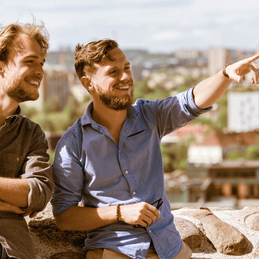 man showing his friend just where to look at 