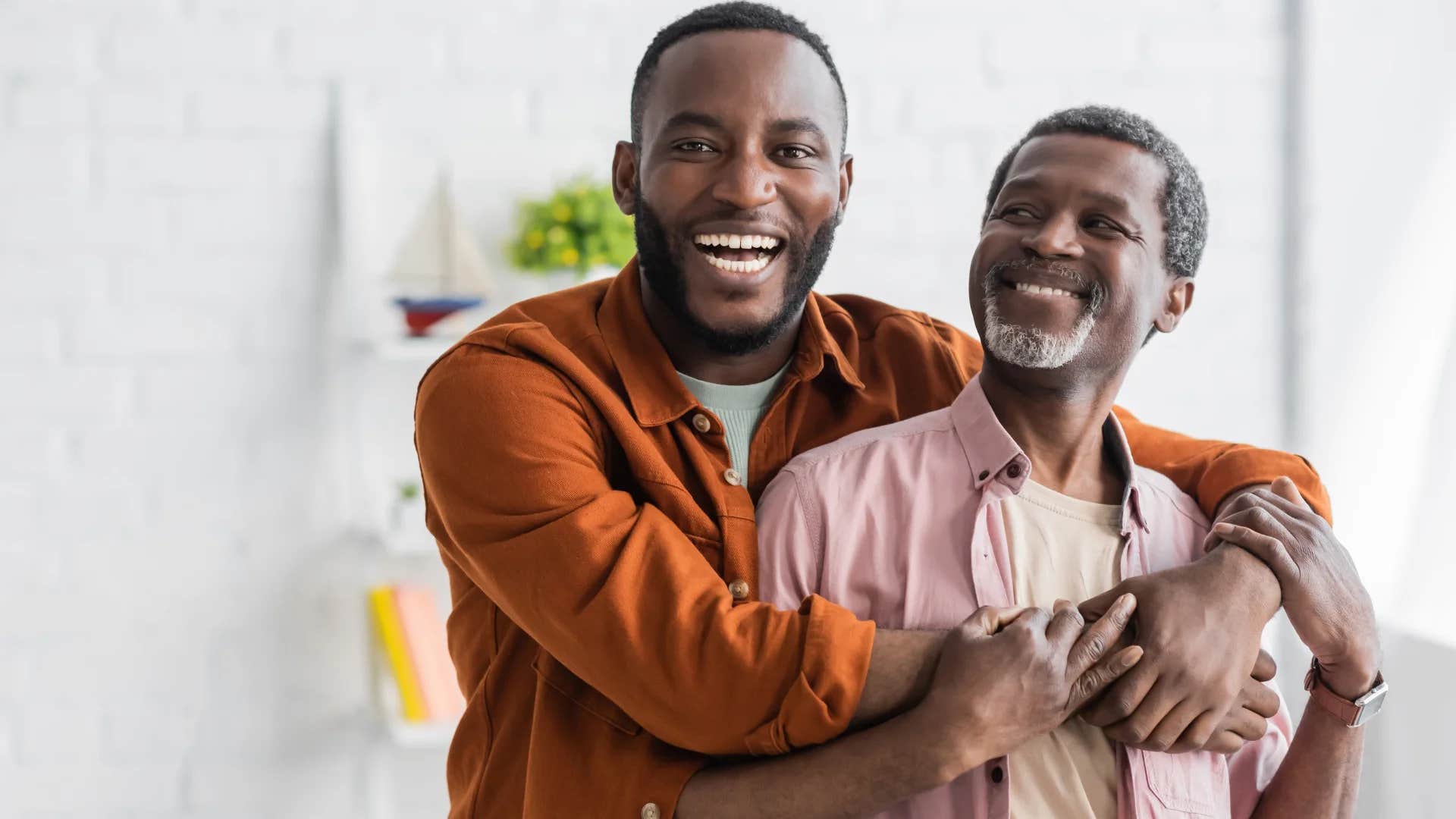 empathetic father smiling while son hugs him